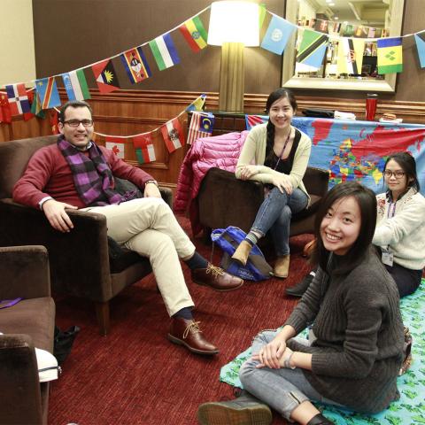 a group of international students from different nations sitting together and smiling for the camera