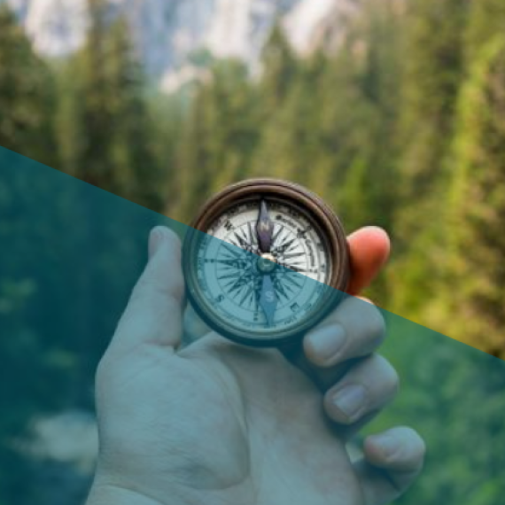 Holding a compass looking out over a forest