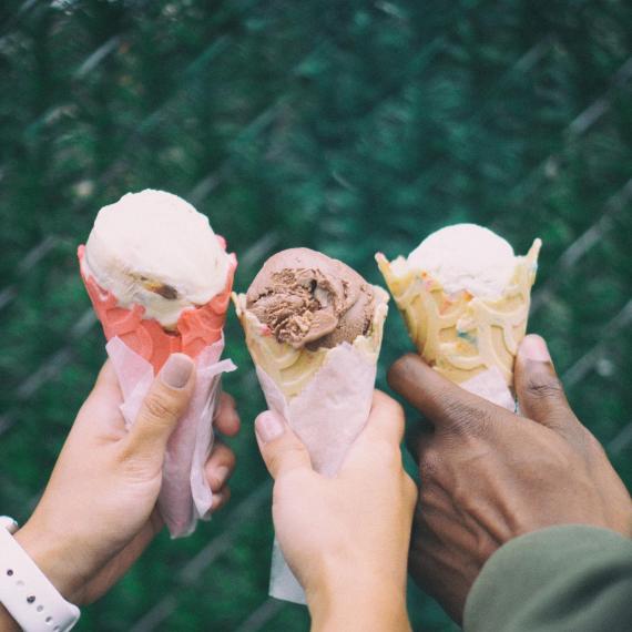 three ice cream cones, held by three people